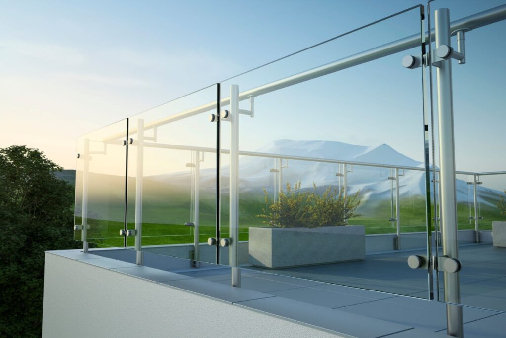 Elegante parapetto in vetro trasparente con montanti in acciaio su un balcone panoramico con vista sulle montagne innevate