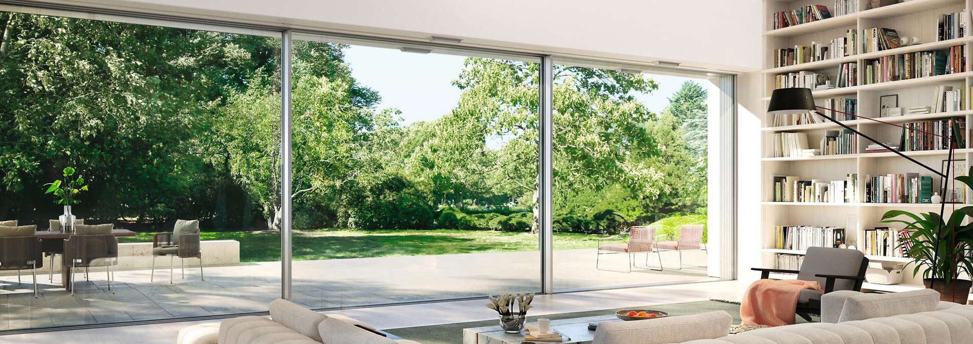 Scorrevoli Schüco Alluminio: comfort e tecnologia senza barriere Vetrata scorrevole Schüco in alluminio a scomparsa su binari ribassati, installata in un salone di lusso con vista su parco alberato.