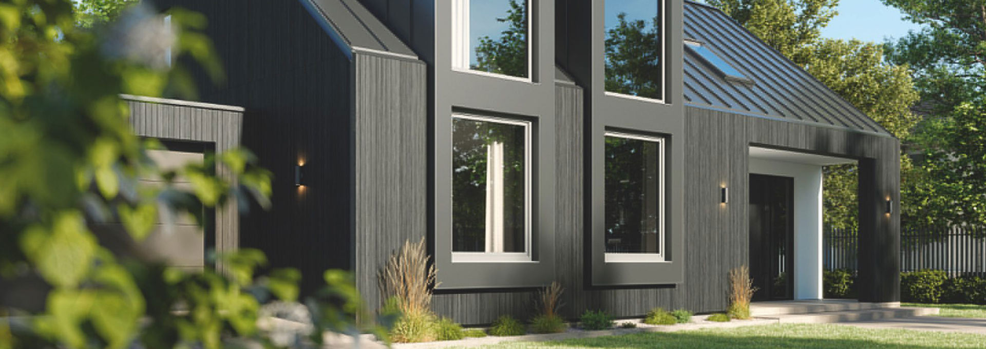 Infissi Schüco PVC a Roma: estetica moderna e massima efficienza Facciata di una villa moderna con infissi Schüco in PVC grigio antracite integrati nel rivestimento esterno scuro.