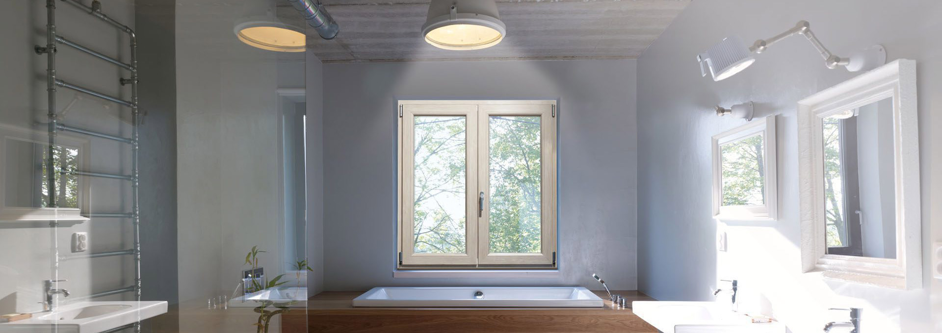Infissi in PVC Schüco: resistenza e comfort anche in bagno Infisso Schüco in PVC a doppio battente installato sopra una vasca da bagno, resistente all'umidità e con alto isolamento termico.