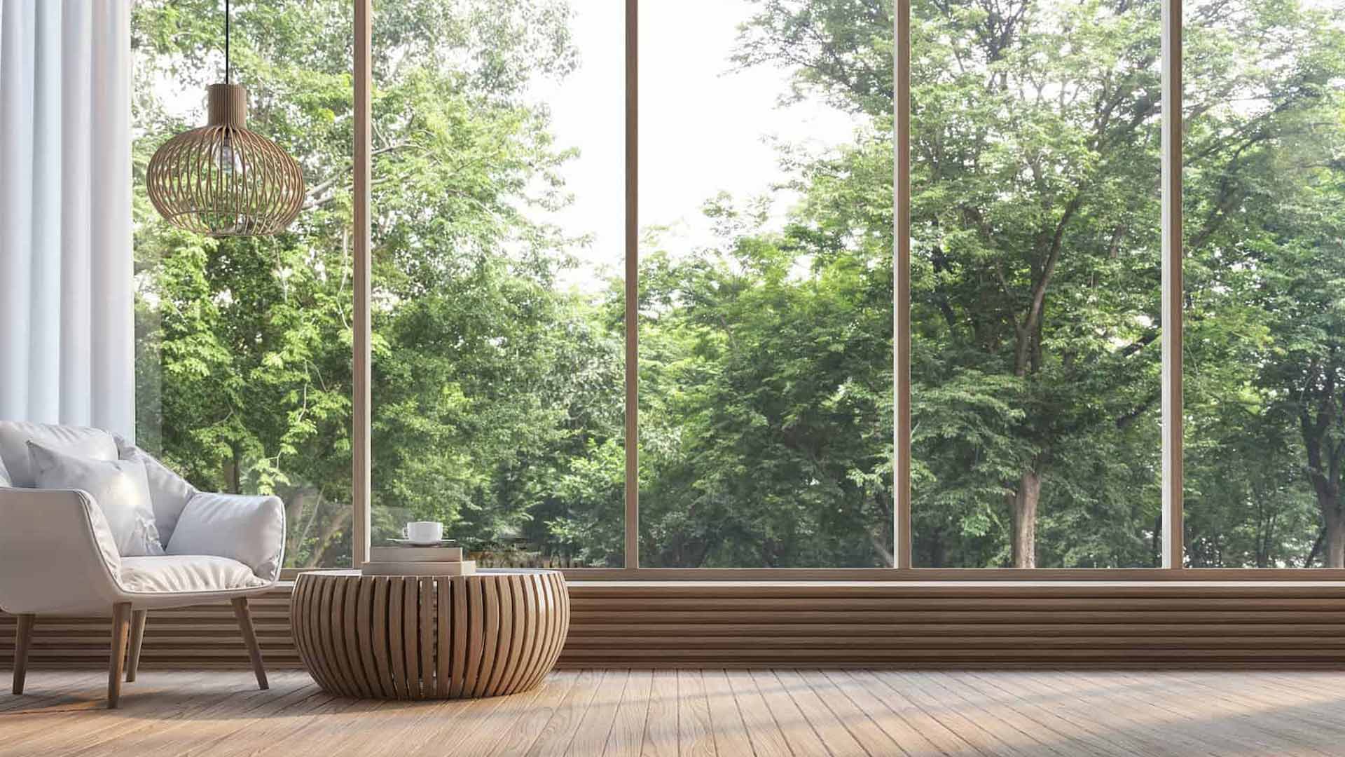 Elegante soggiorno moderno con pareti tortora e due finestre a battente in PVC Sintesi, che garantiscono un elevato isolamento acustico dai palazzi cittadini esterni.
