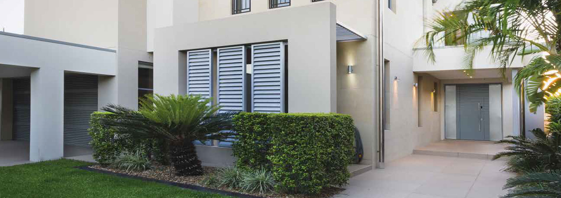 Porte blindate Alias a Roma: sicurezza e architettura moderna Ingresso moderno con porta blindata Alias a filo muro in grigio antracite, installata in una villa con facciata minimalista e sistemi frangisole.