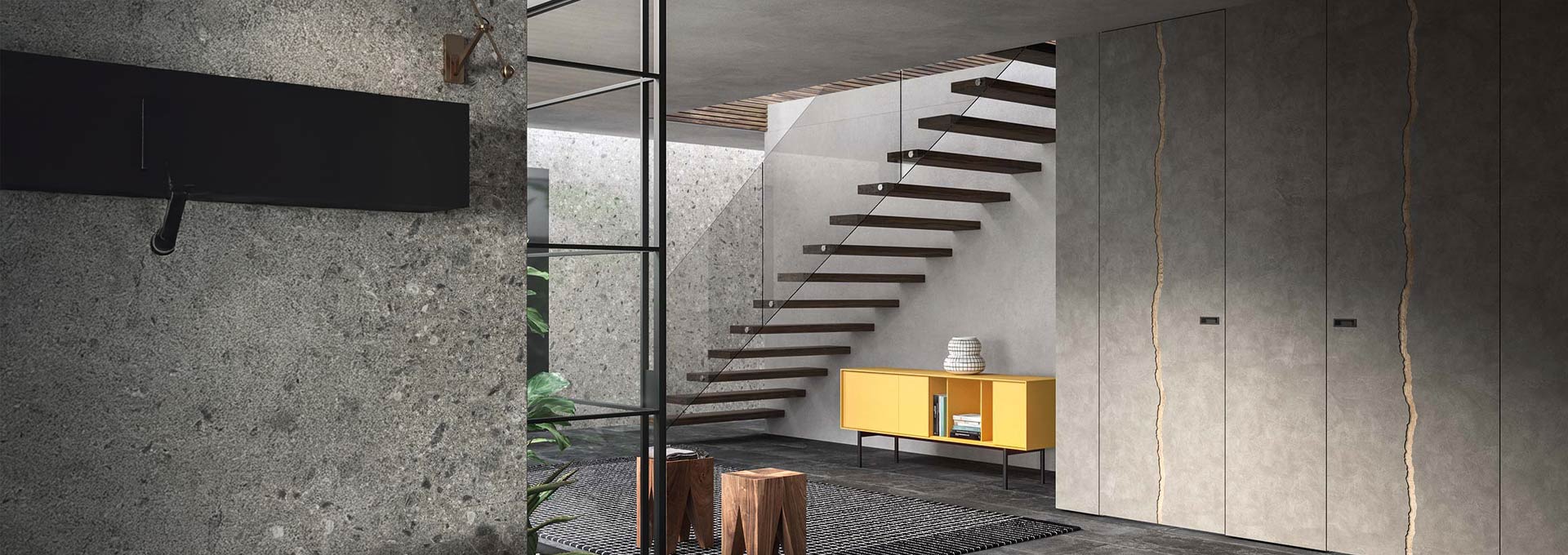 Design materico DoorArreda: porte rasomuro effetto cemento Installazione di porte rasomuro DoorArreda grigio cemento con taglio artistico verticale, integrate in un living dal design industriale e scala a vista.