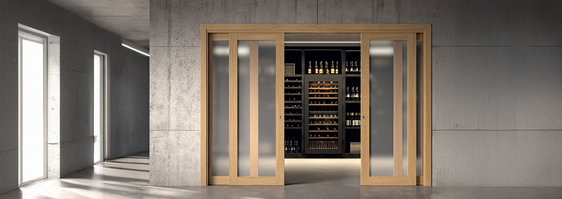 Porte scorrevoli GD Dorigo: separare gli spazi con luce e design Doppia porta scorrevole GD Dorigo in legno chiaro con ampi inserti in vetro satinato, utilizzata per separare un disimpegno da un'elegante cantina vini.