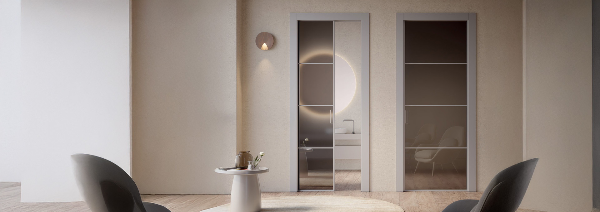 Porte in vetro scorrevoli GD Dorigo: trasparenze e architettura d'interni Sistema di porte scorrevoli GD Dorigo in vetro fumé con profili orizzontali minimali, ideali per separare con raffinatezza la zona bagno dal living.