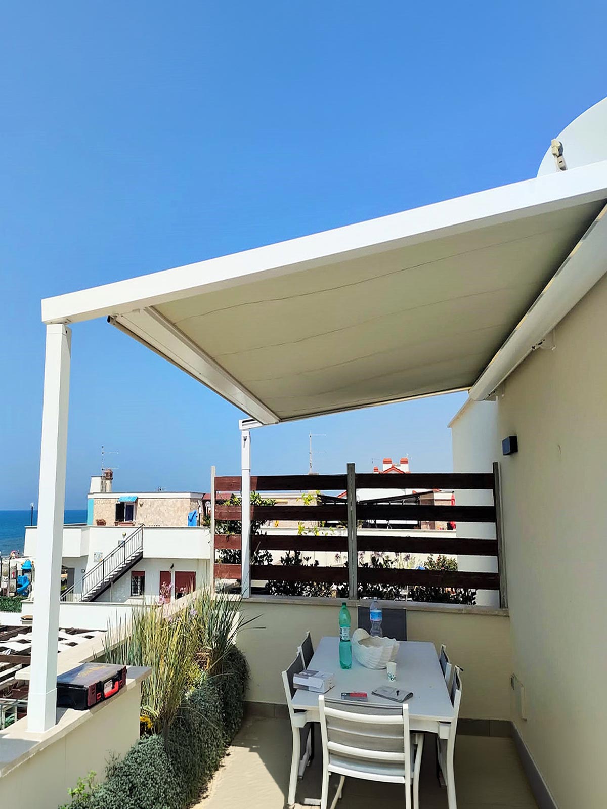 Pergola con tetto retrattile KE Hydra installata su un terrazzo vista mare a Torvaianica