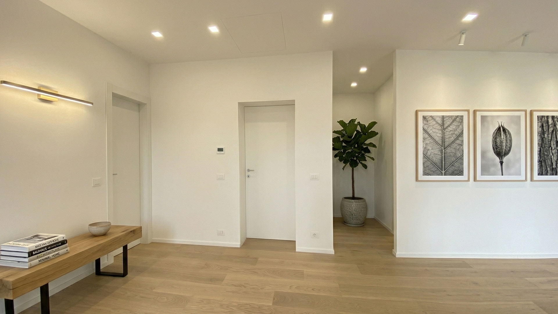 Elegante ingresso di una villa all'Olgiata con porta filomuro bianca DoorArreda e pianta decorativa