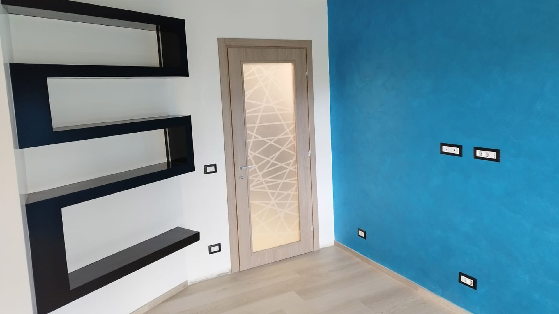 Porta interna in legno chiaro con vetro decorato inserita in camera dal design contemporaneo