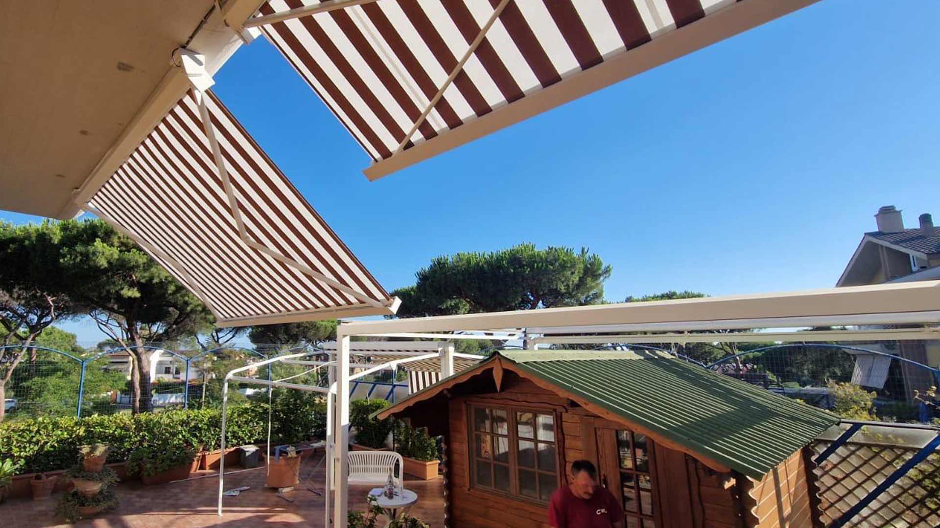 Struttura outdoor bianca chiusa con vetrate panoramiche scorrevoli su prato sintetico