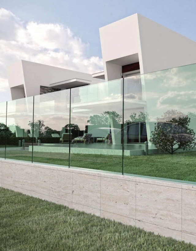 Dettaglio di un parapetto in vetro Faraone serie Ninfa installato a pavimento, davanti a una villa moderna dal design minimalista.