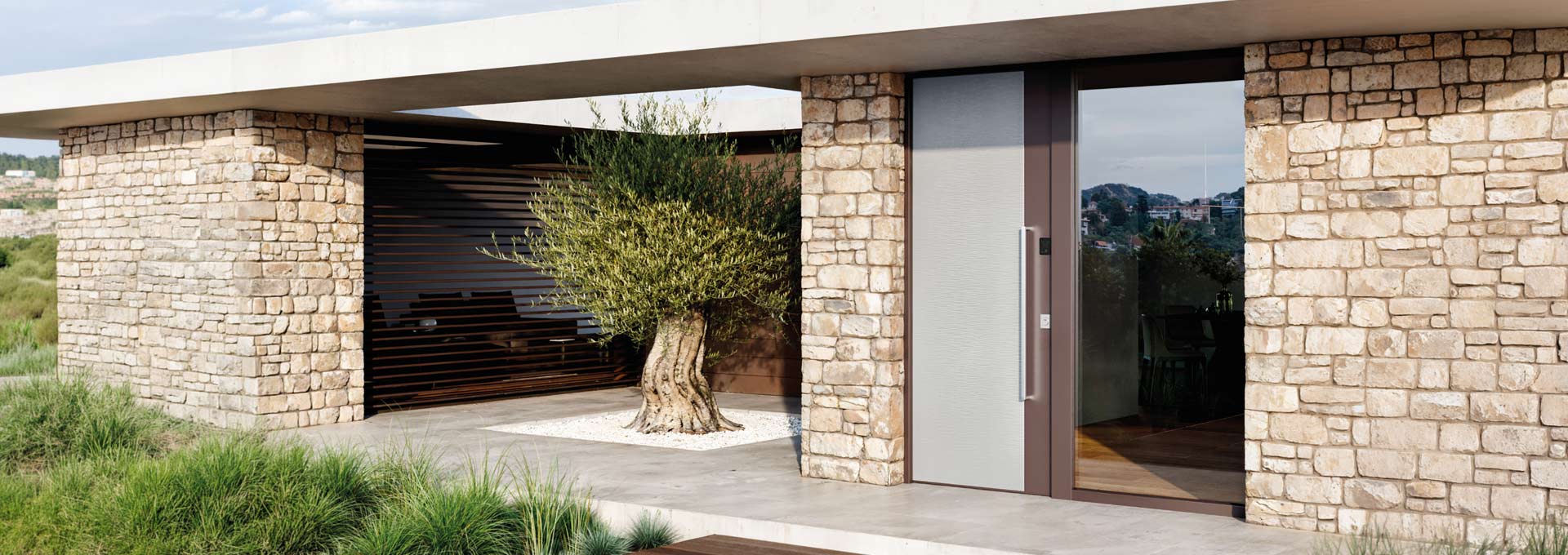 Sicurezza hi-tech Okey: portoni blindati Classe 4 a Roma Ingresso di sicurezza Okey con porta blindata bicolore e grande maniglione verticale, incastonata in una parete in pietra naturale.