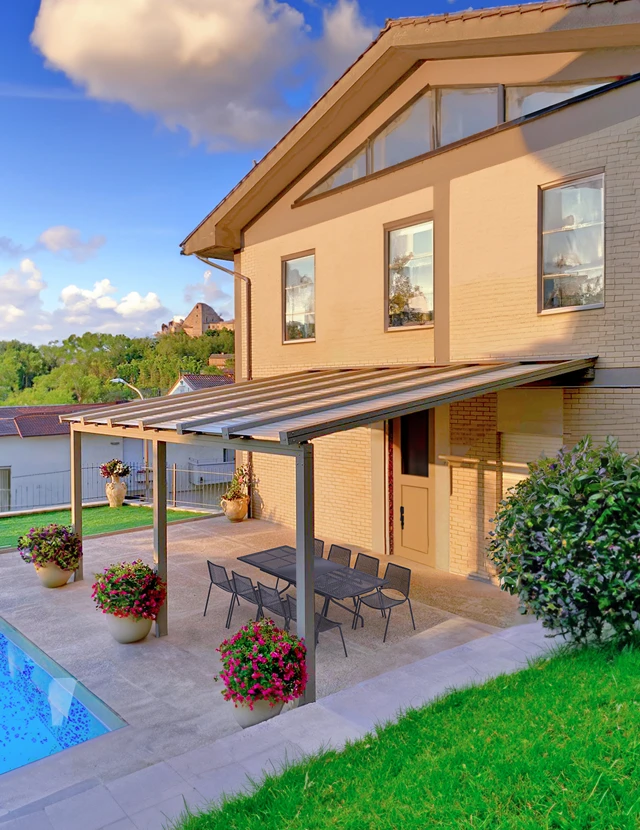 Pergola addossata in alluminio Giulio Barbieri modello 3Facile con copertura fissa, installata a bordo piscina in una villa.
