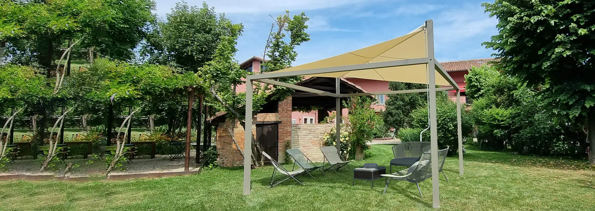 Vele da giardino Giulio Barbieri a Roma: crea la tua oasi di fresco immersa nel verde. Vela ombreggiante autoportante Giulio Barbieri con tessuto tecnico chiaro, perfettamente integrata in un rigoglioso giardino privato con sedute relax.